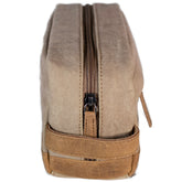 A brown canvas toiletry bag  and leather details, featuring a zipper closure and a brand logo embossed on the front.